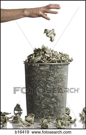 Person throwing crumpled money into waste paper basket View Large Photo Image Stock Photo - Person throwing crumpled money into waste paper basket. Fotosearch
