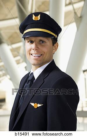 Pilot smiling in airport View Large Photo Image Stock Image - Pilot smiling in airport. Fotosearch