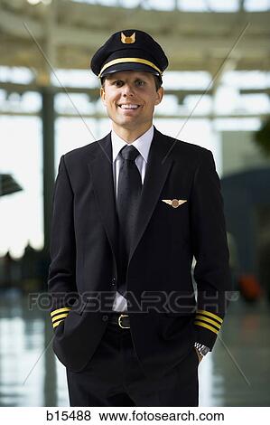 Pilot standing and smiling in airport View Large Photo Image Stock Photo - Pilot standing and smiling in airport. Fotosearch