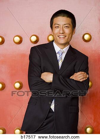 Stock Photo - Portrait of a businessman with arms crossed smiling. Fotosearch