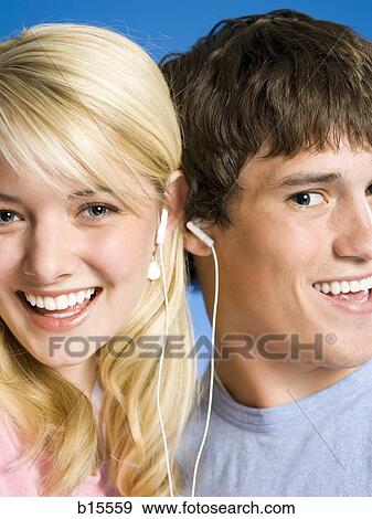 Portrait of a young couple with ear buds smiling View Large Photo Image Stock Photo - Portrait of a young couple with ear buds smiling. Fotosearch