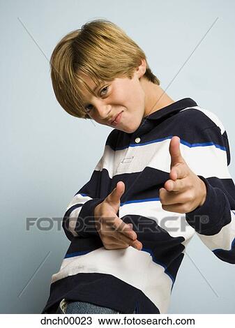 Stock Image - Portrait of boy making shooting gesture with hands. Fotosearch