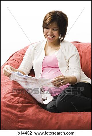 Pregnant Woman holding baby clothing. View Large Photo Image Stock Image - Pregnant Woman holding baby clothing.. Fotosearch