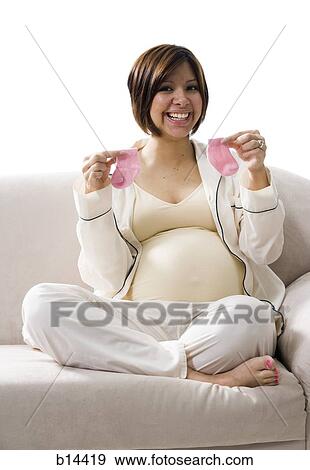 Pregnant Woman holding baby clothing. View Large Photo Image Stock Photo - Pregnant Woman holding baby clothing.. Fotosearch