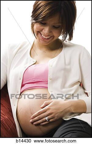 Stock Image - Pregnant Woman holding stomach.. Fotosearch
