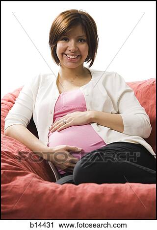 Stock Image - Pregnant Woman holding stomach.. Fotosearch