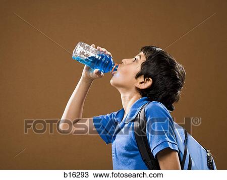 Profile of boy with backpack drinking beverage from plastic bottle View Large Photo Image Stock Image - Profile of boy with backpack drinking beverage from plastic bottle. Fotosearch