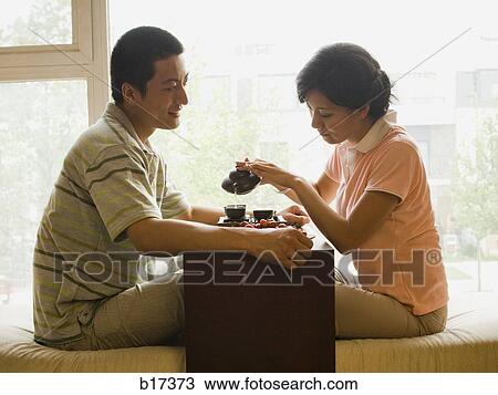 Profile of couple sitting cross legged with tea and fruit with large window in background View Large Photo Image Stock Image - Profile of couple sitting cross legged with tea and fruit with large window in background. Fotosearch