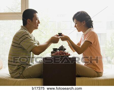 Profile of couple sitting cross legged with tea and fruit with large window in background View Large Photo Image Stock Photography - Profile of couple sitting cross legged with tea and fruit with large window in background. Fotosearch