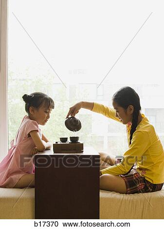 Profile of two girls sitting cross legged having tea View Large Photo Image Stock Image - Profile of two girls sitting cross legged having tea. Fotosearch