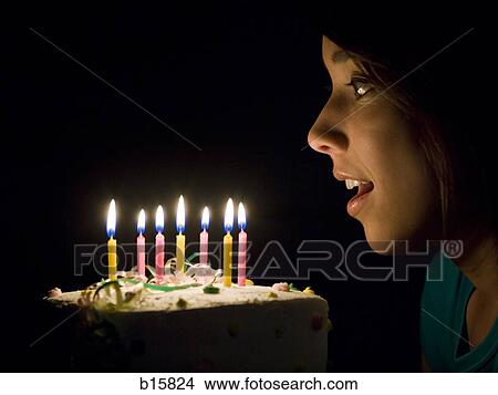 Profile of woman blowing out candles on birthday cake View Large Photo Image Picture - Profile of woman blowing out candles on birthday cake. Fotosearch