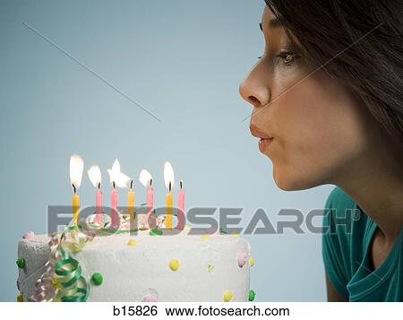 Profile of woman blowing out candles on birthday cake View Large Photo Image Stock Photograph - Profile of woman blowing out candles on birthday cake. Fotosearch