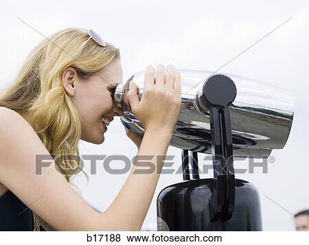 Profile of woman looking through coin operated binoculars smiling View Large Photo Image Stock Photo - Profile of woman looking through coin operated binoculars smiling. Fotosearch