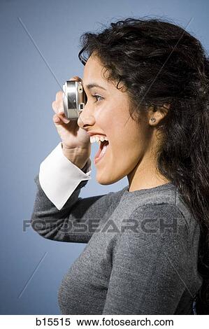 Profile of woman taking a photo with digital camera smiling View Large Photo Image Stock Photography - Profile of woman taking a photo with digital camera smiling. Fotosearch