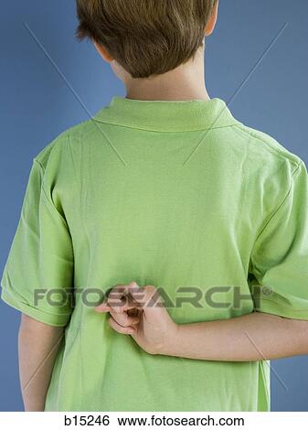 Rear view of boy with fingers crossed behind back View Large Photo Image Stock Photograph - Rear view of boy with fingers crossed behind back. Fotosearch