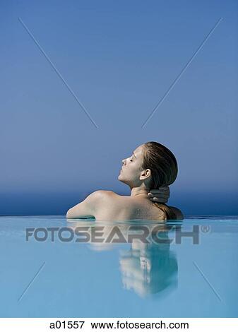 Rear view of woman in pool with eyes closed leaning View Large Photo Image Stock Photo - Rear view of woman in pool with eyes closed leaning. Fotosearch