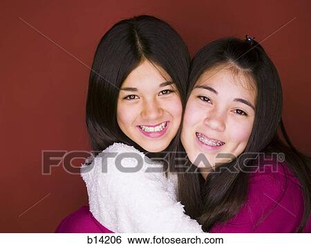 Sisters smiling and hugging. View Large Photo Image Stock Photograph - Sisters smiling and hugging.. Fotosearch