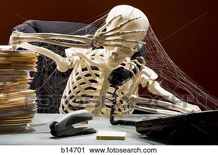 Skeleton sitting at desk talking on telephone with webs and stacks of paperwork View Large Photo Image Stock Image - Skeleton sitting at desk talking on telephone with webs and stacks of paperwork. Fotosearch