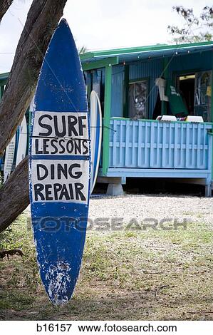 Surfboard outdoors with Surf Lessons and Ding Repair sign View Large Photo Image Stock Photo - Surfboard outdoors with Surf Lessons and Ding Repair sign. Fotosearch