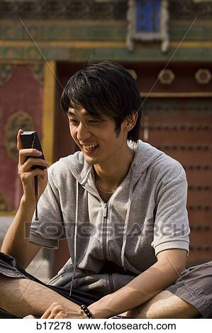 Teenage boy outdoors with cell phone smiling View Large Photo Image Stock Photo - Teenage boy outdoors with cell phone smiling. Fotosearch