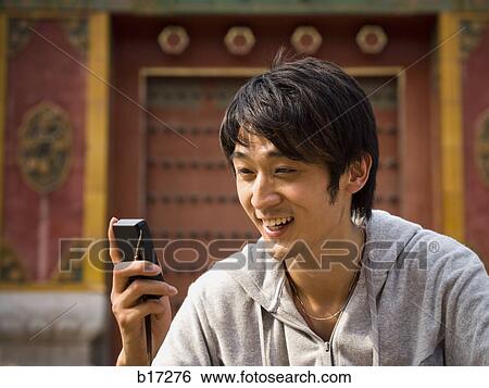Teenage boy outdoors with cell phone smiling View Large Photo Image Stock Photograph - Teenage boy outdoors with cell phone smiling. Fotosearch