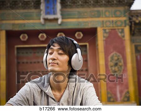 Teenage boy outdoors with eyes closed and headphones View Large Photo Image Stock Photograph - Teenage boy outdoors with eyes closed and headphones. Fotosearch
