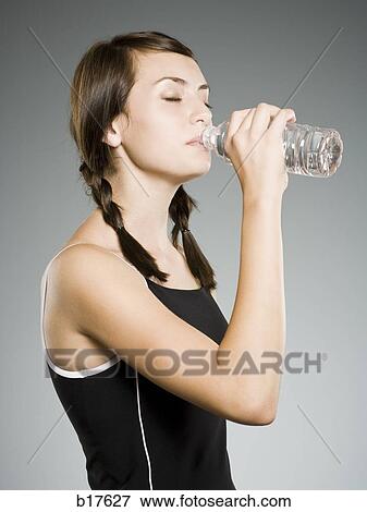 Teenage girl drinking bottled water View Large Photo Image Stock Photo - Teenage girl drinking bottled water. Fotosearch