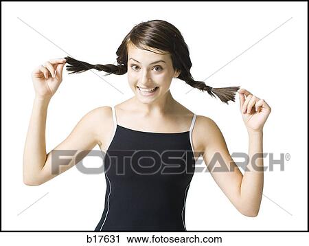 Teenage girl holding braids and smiling View Large Photo Image Stock Image - Teenage girl holding braids and smiling. Fotosearch