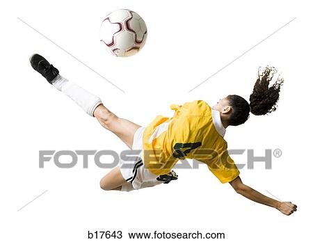 Stock Image - Teenage girl kicking soccer ball. Fotosearch