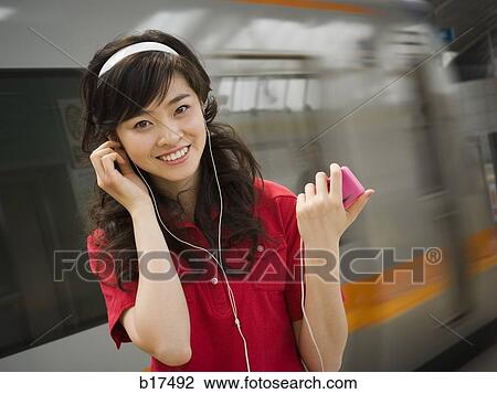 Teenage girl listening to mp3 player smiling View Large Photo Image Stock Image - Teenage girl listening to mp3 player smiling. Fotosearch