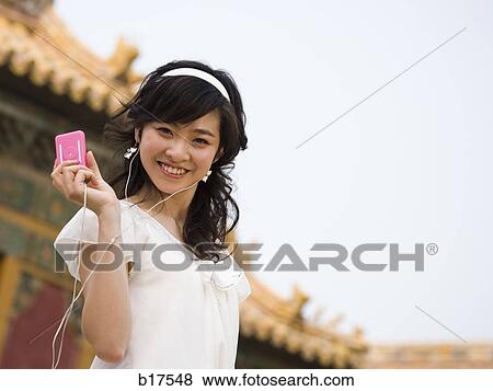 Teenage girl listening to mp3 player and smiling View Large Photo Image Stock Photo - Teenage girl listening to mp3 player and smiling. Fotosearch