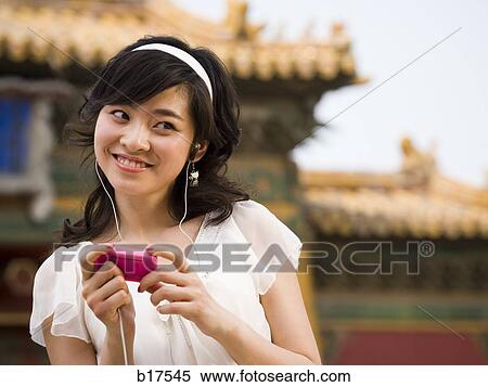 Teenage girl listening to mp3 player and smiling View Large Photo Image Stock Photography - Teenage girl listening to mp3 player and smiling. Fotosearch