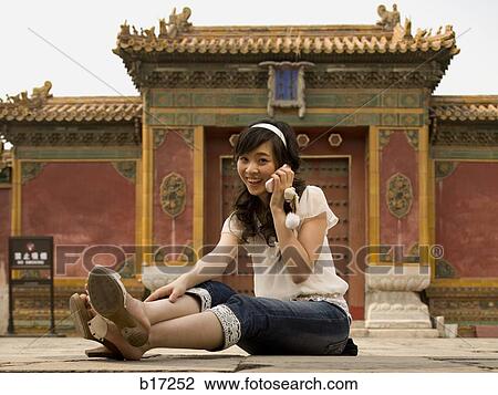 Teenage girl sitting outdoors talking on cell phone View Large Photo Image Stock Image - Teenage girl sitting outdoors talking on cell phone. Fotosearch