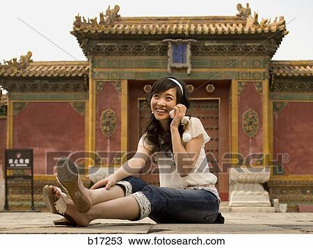 Teenage girl sitting outdoors talking on cell phone View Large Photo Image Stock Image - Teenage girl sitting outdoors talking on cell phone. Fotosearch