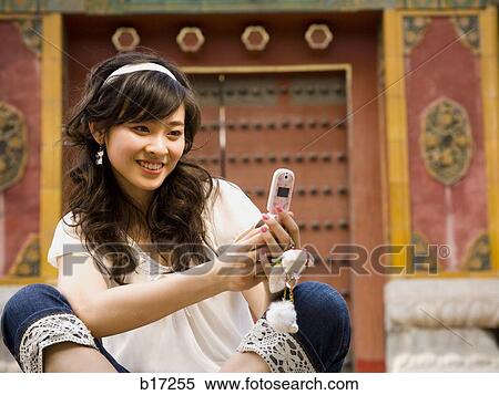 Teenage girl sitting outdoors with cell phone View Large Photo Image Stock Photography - Teenage girl sitting outdoors with cell phone. Fotosearch
