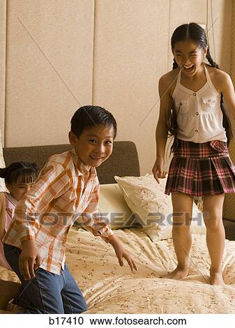 Three children jumping on bed laughing View Large Photo Image Stock Image - Three children jumping on bed laughing. Fotosearch