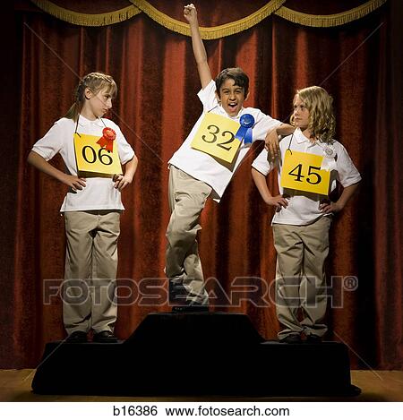 Three children on stage at winner's podium with ribbons smiling View Large Photo Image Stock Photograph - Three children on stage at winner's podium with ribbons smiling. Fotosearch