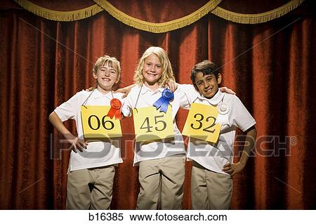 Three children on stage at winner's podium with ribbons smiling View Large Photo Image Stock Photography - Three children on stage at winner's podium with ribbons smiling. Fotosearch