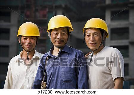 Three male construction workers with helmets outdoors smiling View Large Photo Image Stock Image - Three male construction workers with helmets outdoors smiling. Fotosearch