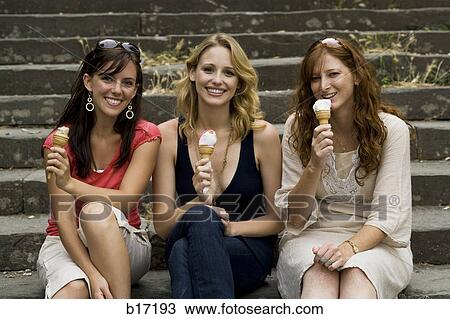 Three women sitting on steps outdoors eating ice cream cones smiling View Large Photo Image Stock Image - Three women sitting on steps outdoors eating ice cream cones smiling. Fotosearch