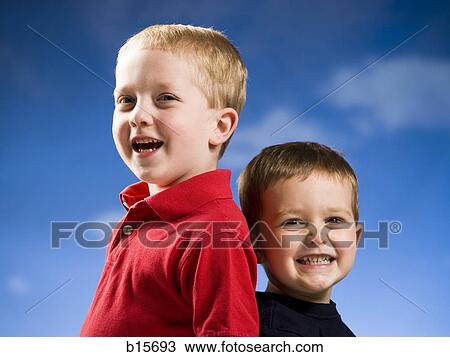 Two boys smiling with blue sky View Large Photo Image Stock Image - Two boys smiling with blue sky. Fotosearch