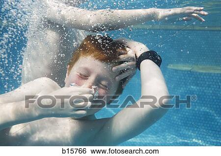Two boys swimming underwater View Large Photo Image Stock Photograph - Two boys swimming underwater. Fotosearch