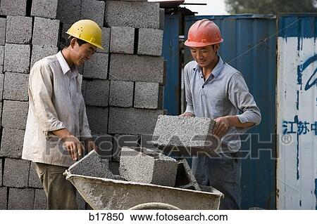 Stock Image - Two construction workers on the job site.. Fotosearch