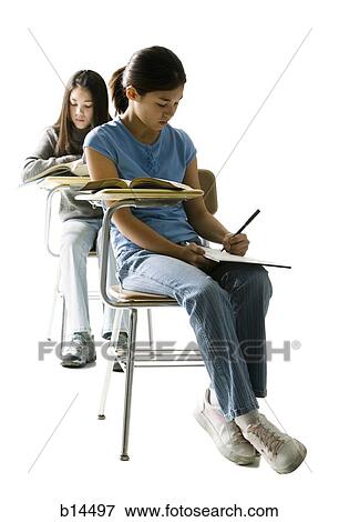 Two girls at school desks doing written work View Large Photo Image Stock Photo - Two girls at school desks doing written work. Fotosearch