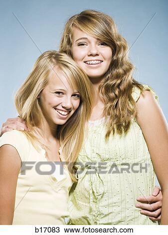 Two girls embracing and smiling View Large Photo Image Stock Image - Two girls embracing and smiling. Fotosearch