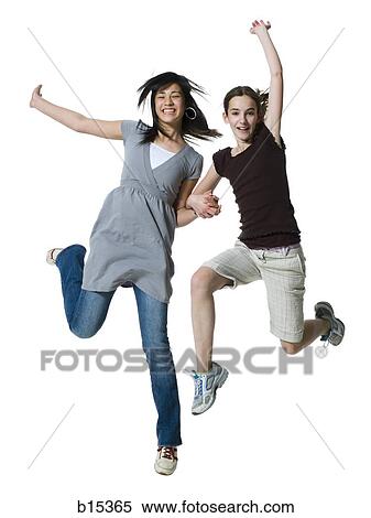 Two girls jumping and smiling View Large Photo Image Stock Photography - Two girls jumping and smiling. Fotosearch
