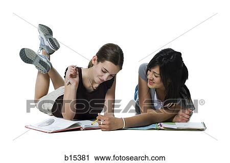 Two girls lying down doing homework View Large Photo Image Stock Image - Two girls lying down doing homework. Fotosearch