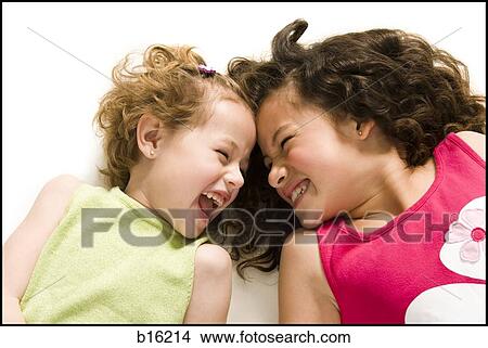 Two girls lying down laughing View Large Photo Image Picture - Two girls lying down laughing. Fotosearch