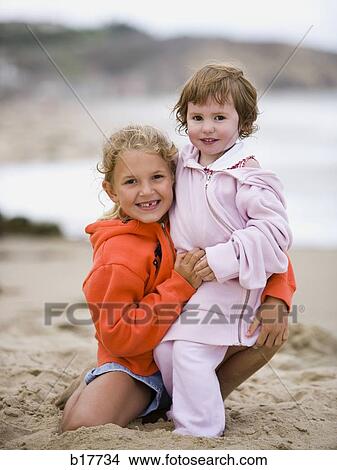 Two girls on beach embracing and smiling View Large Photo Image Picture - Two girls on beach embracing and smiling. Fotosearch