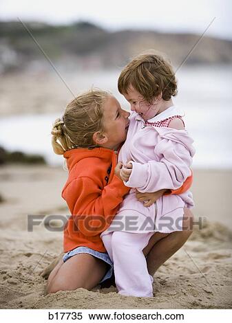 Two girls on beach embracing and smiling View Large Photo Image Stock Photography - Two girls on beach embracing and smiling. Fotosearch